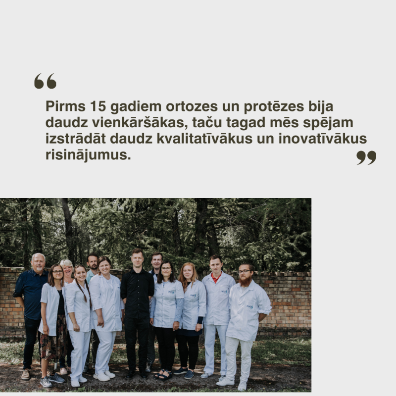 Cilvēku grupa, daži medicīnas mēteļos, kopā stāv ārā pie ķieģeļu sienas ar kokiem fonā. Virs tiem ir citāts svešvalodā.